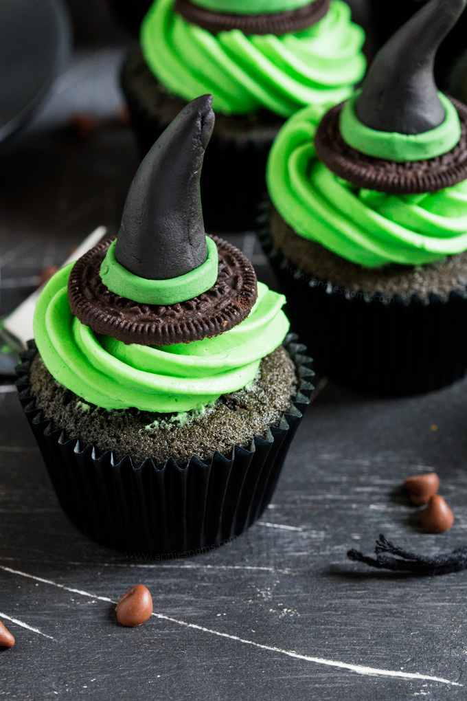 These Witches Hat #Cupcakes are a cute and fun way to get creative this #Halloween. A black chocolate chip cupcake is topped with green frosting and a handmade witches hat topper! #ad