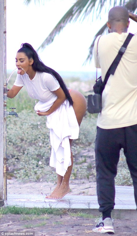 Hitting back: Kim was handed a cell phone to look at the images online by her assistant Stephanie Shepherd