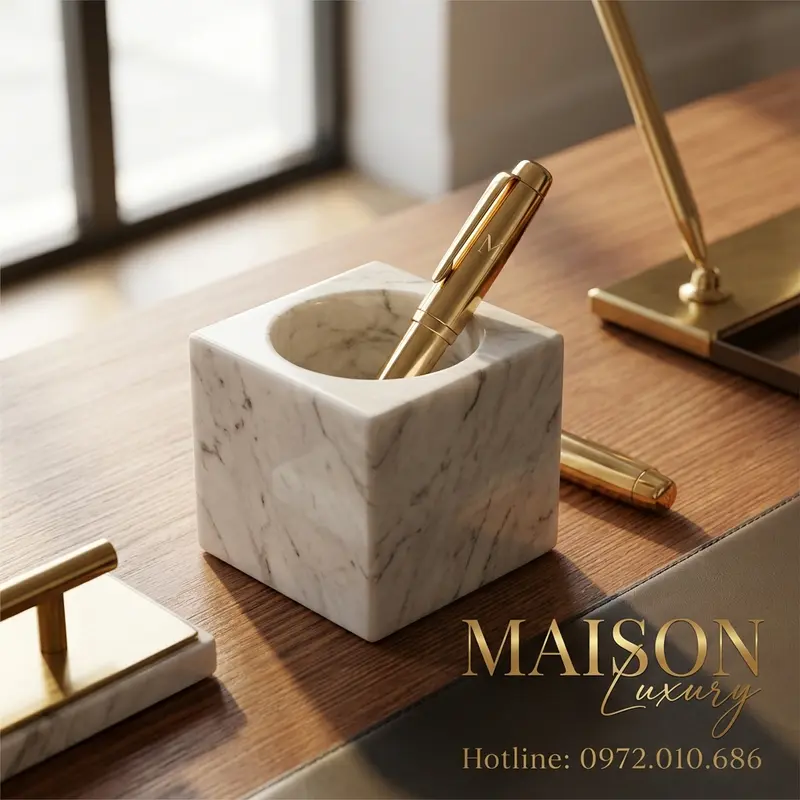 Bộ đế giấy bằng đá marble và bút mạ vàng – biểu tượng trường tồn của thương hiệu trên bàn làm việc.