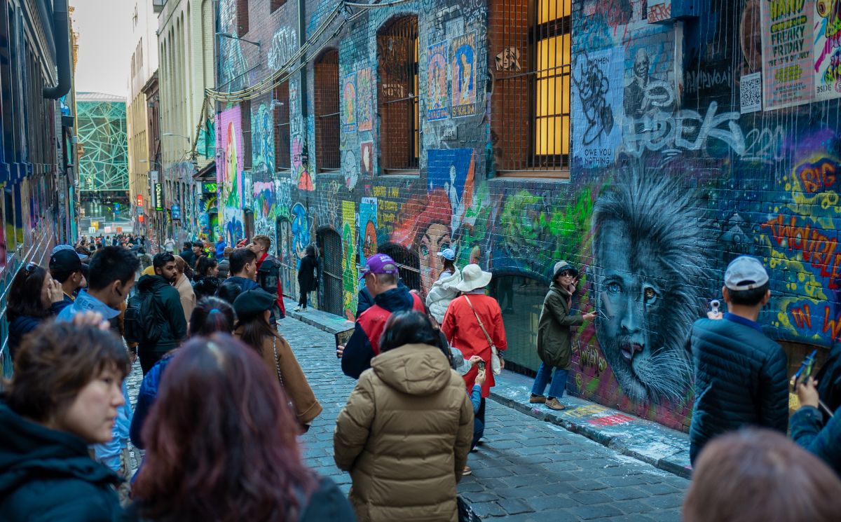Tourists watching a street artist in one of Melbourne's famous laneways