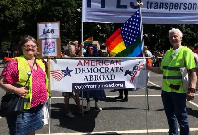 Cheryl and Rick holding the American Democrats Abroad banner