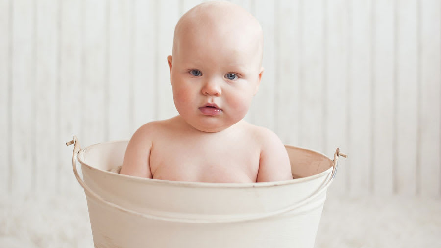 Baby sitting in a white bathtub