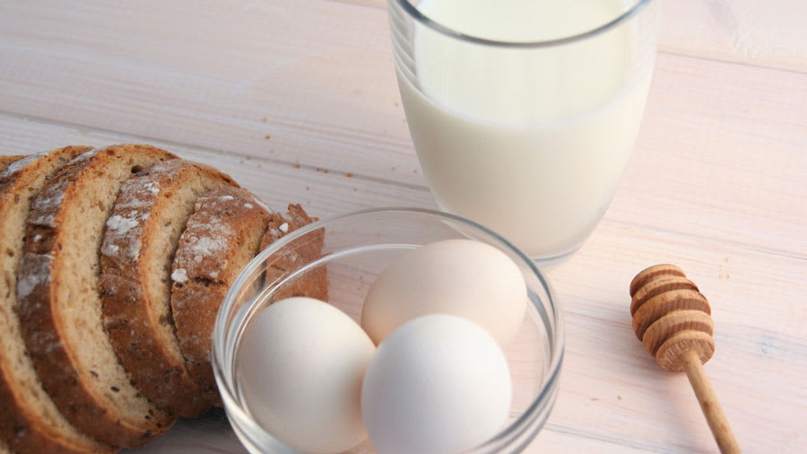 ​Eggs, bread, and milk, on a white wooden table
