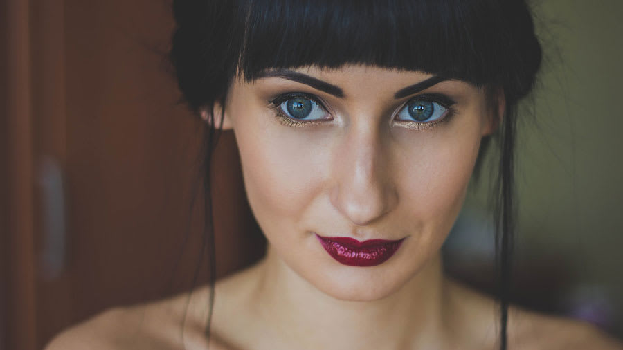beautiful woman with dark red lipstick and colored eyes