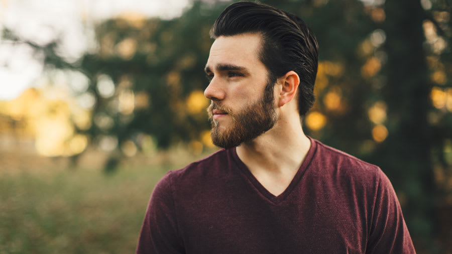 Man in field about to shave his beard without getting razor burn