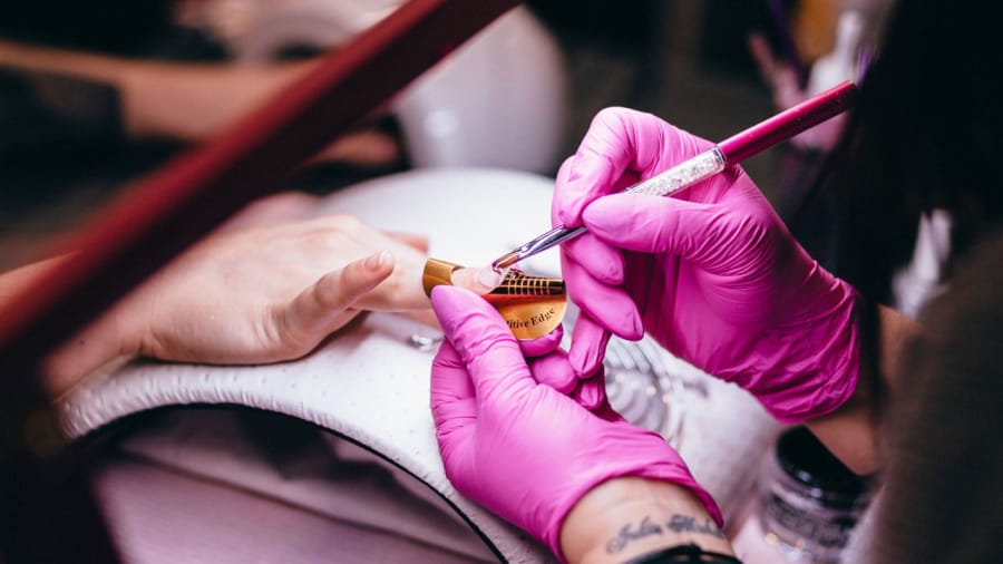 manicurist pushing nail cuticles back