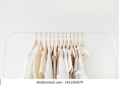 Minimal fashion clothes concept. Female blouses and t-shirts on hanger on white background. Fashion blog, website, social media hero header.