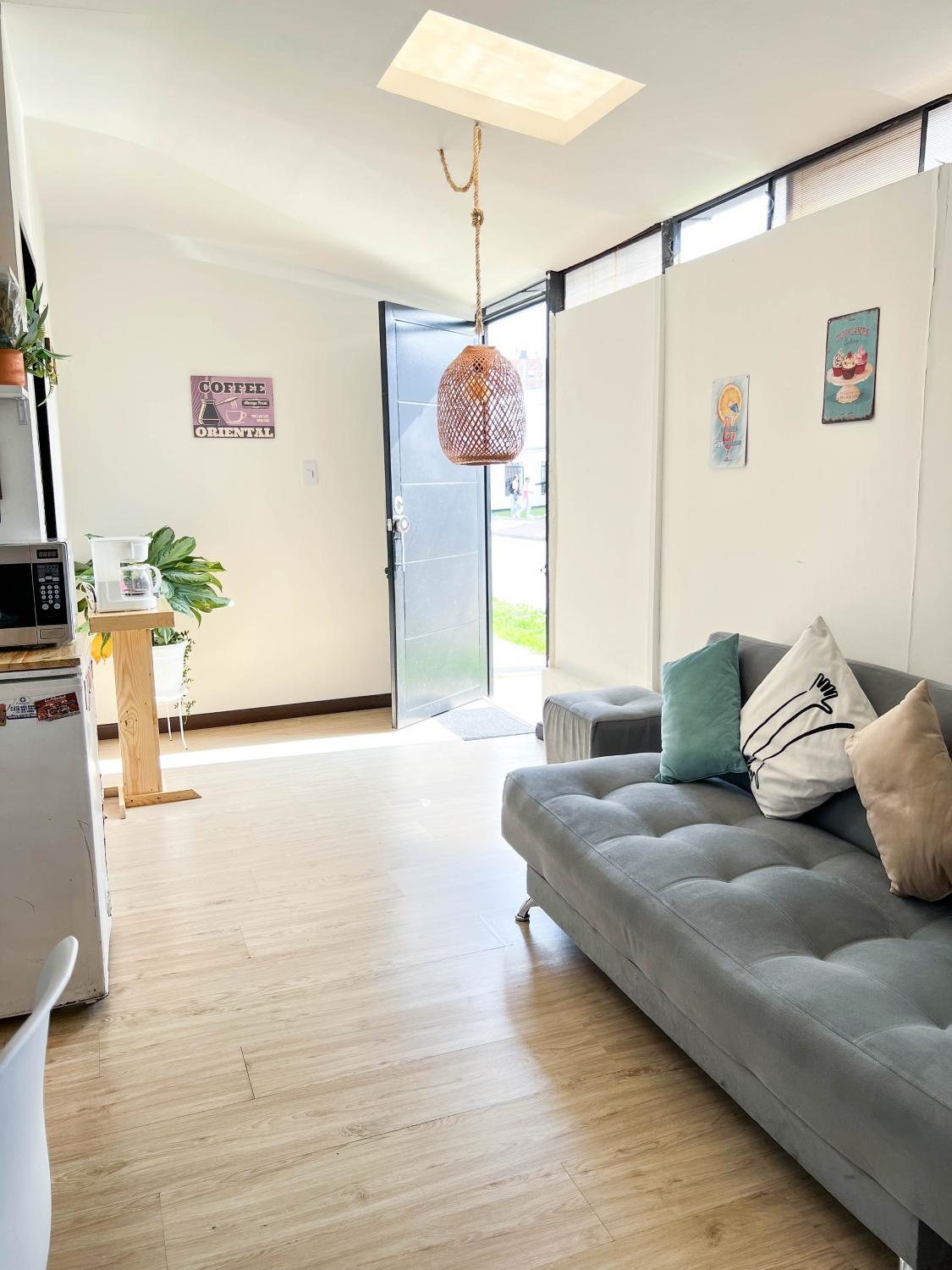 Habitación de apartaestudio con sofá y puerta