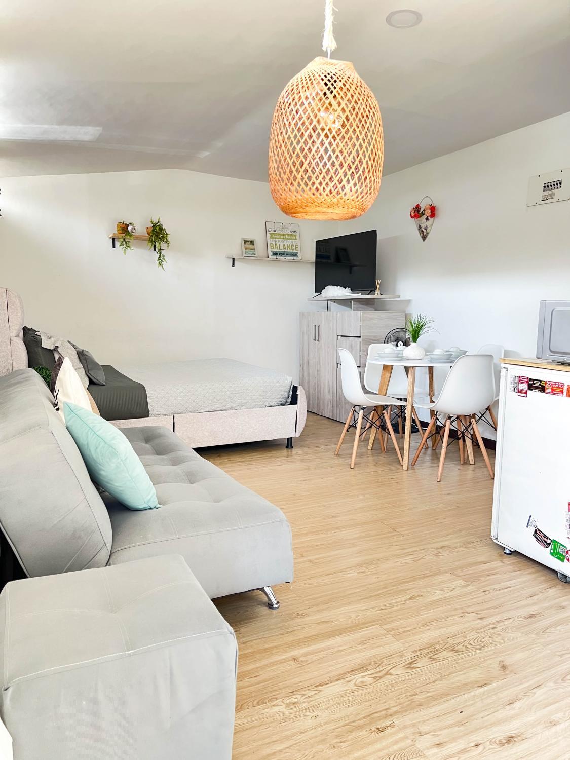 Habitación en apartaestudio con una lámpara, un sofá, y un televisor