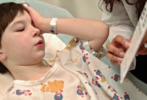 A boy with conjunctivitis takes an eye exam.