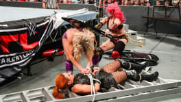 Asuka frappant Charlotte Flair avec une chaise, pendant qu'elle attachait Becky Lynch à une échelle