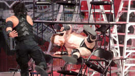 Roman Reigns projetant Sheamus dans une pile de tables et de chaises