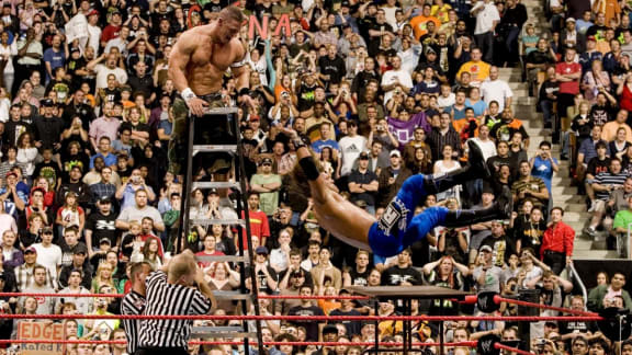 John Cena projette Edge sur des tables depuis une échelle