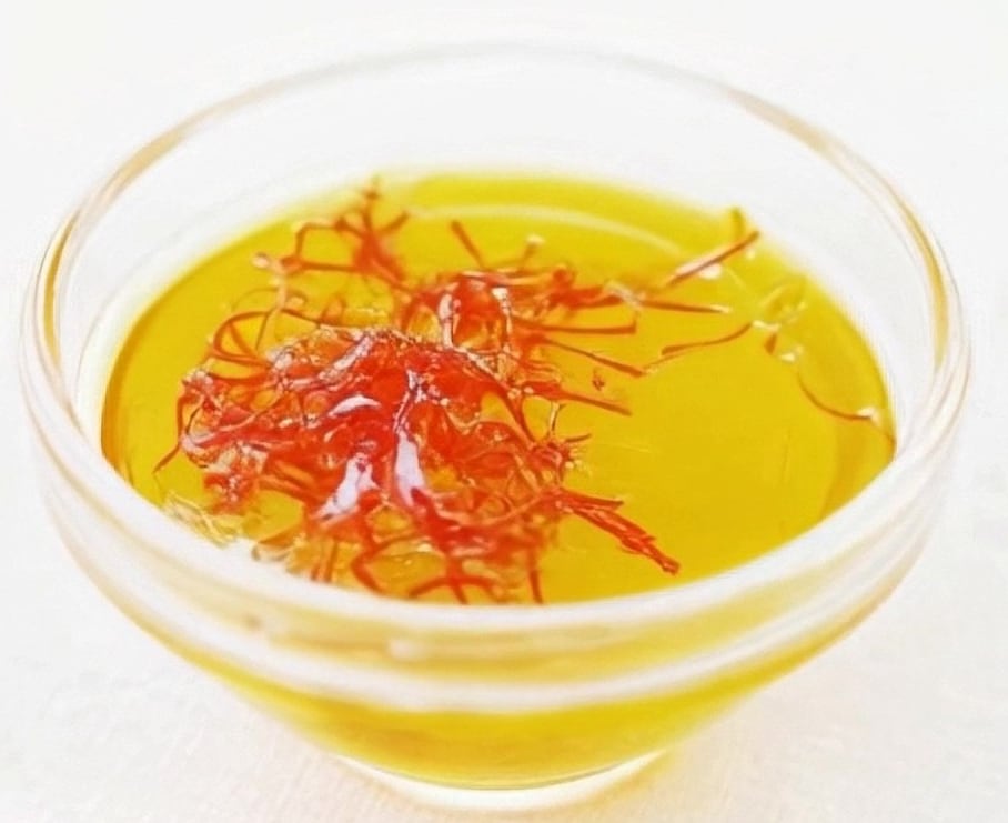 saffron in chicken stock in a glass measuring cup