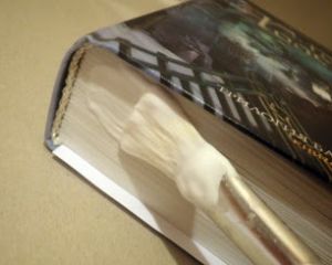 Промазывание клеем нижнего обреза книжного блока