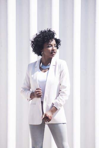 Girl in smart attire standing in front of striped wall