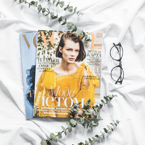Vogue magazines on top of white bedsheets
