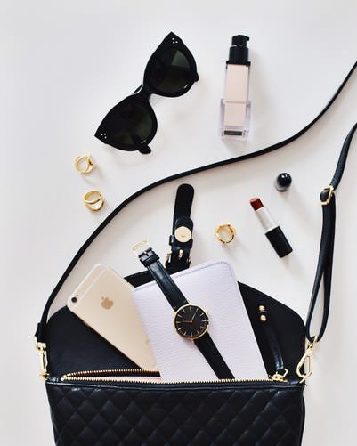 Beauty products spilling out of a black sidebag