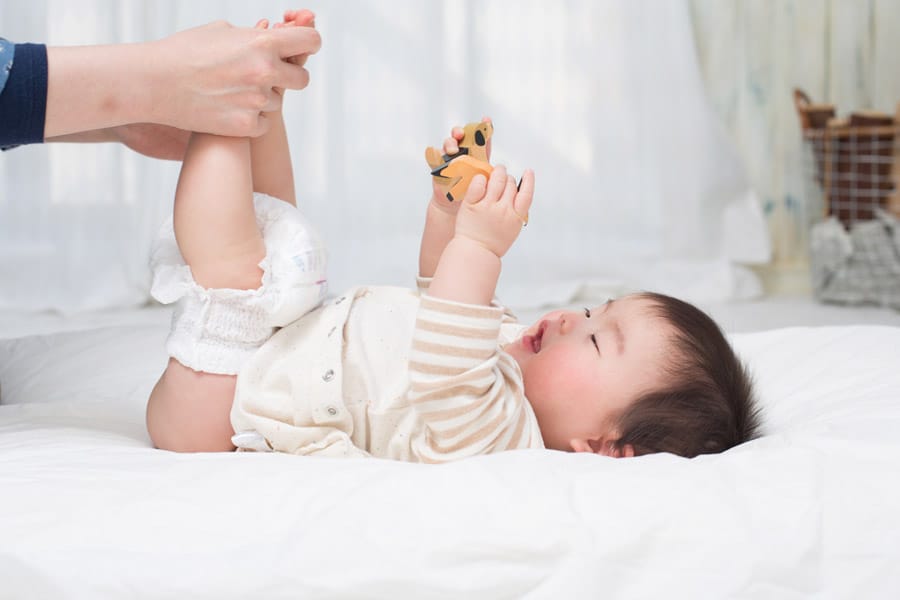 A mother changing baby's diaper