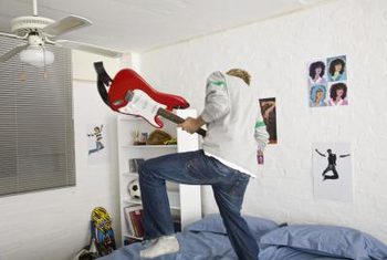 Jupiterimages/Goodshoot/Getty Images He can change his posters as often as he changes his mind with adhesive poster hangers.