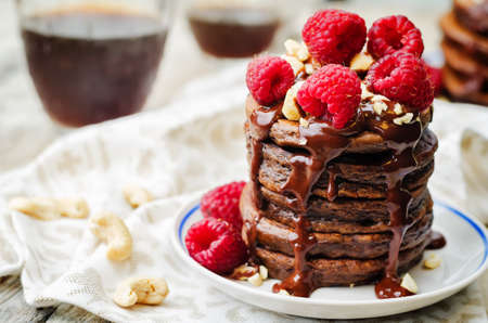 Chocolate pancake with bananas, nuts, chocolate sauce and glass of coffee. the toning. selective focus