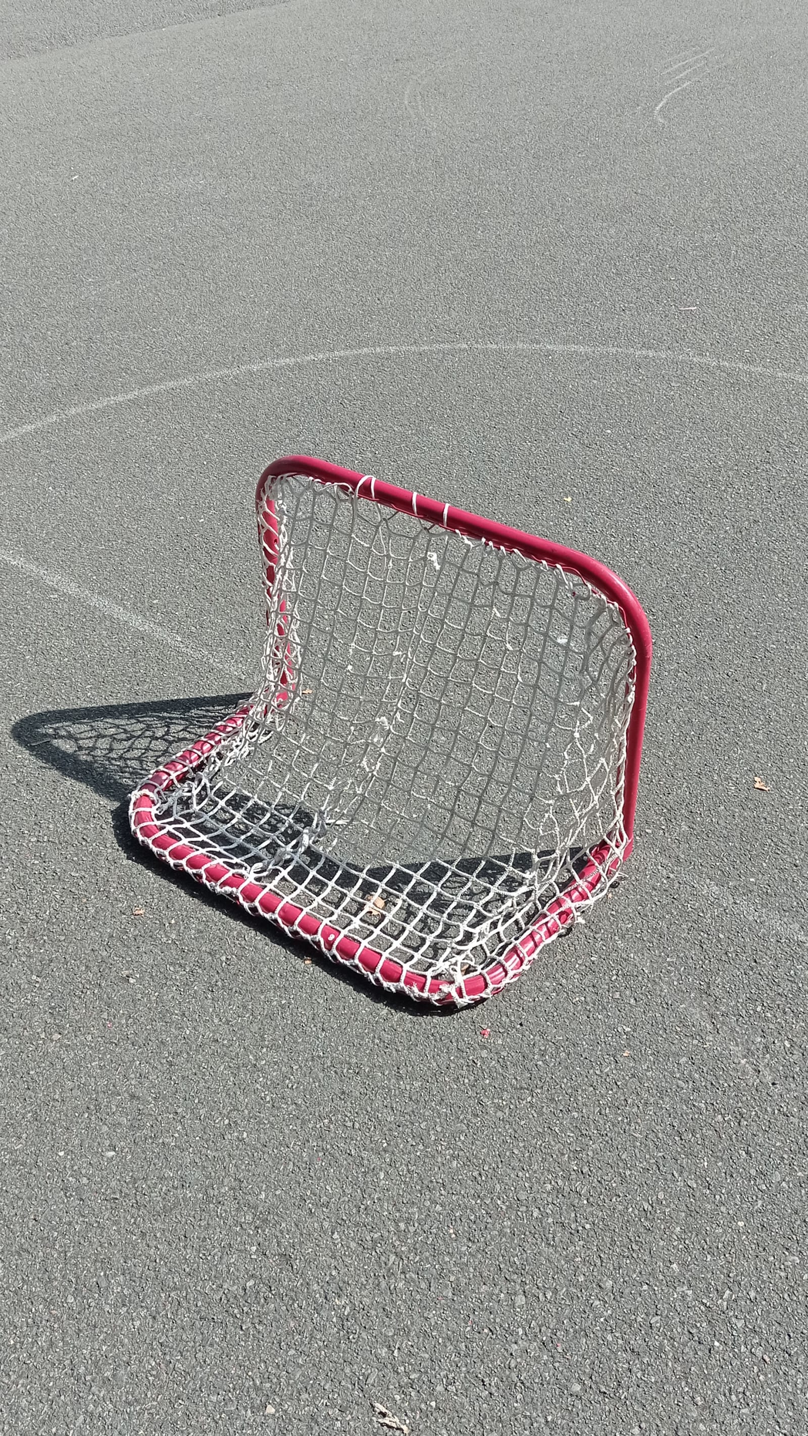 life goals and safety nets - a red tiny structure is left on the ground to hold a white net - aluminium, white net, red paint - paul lahana