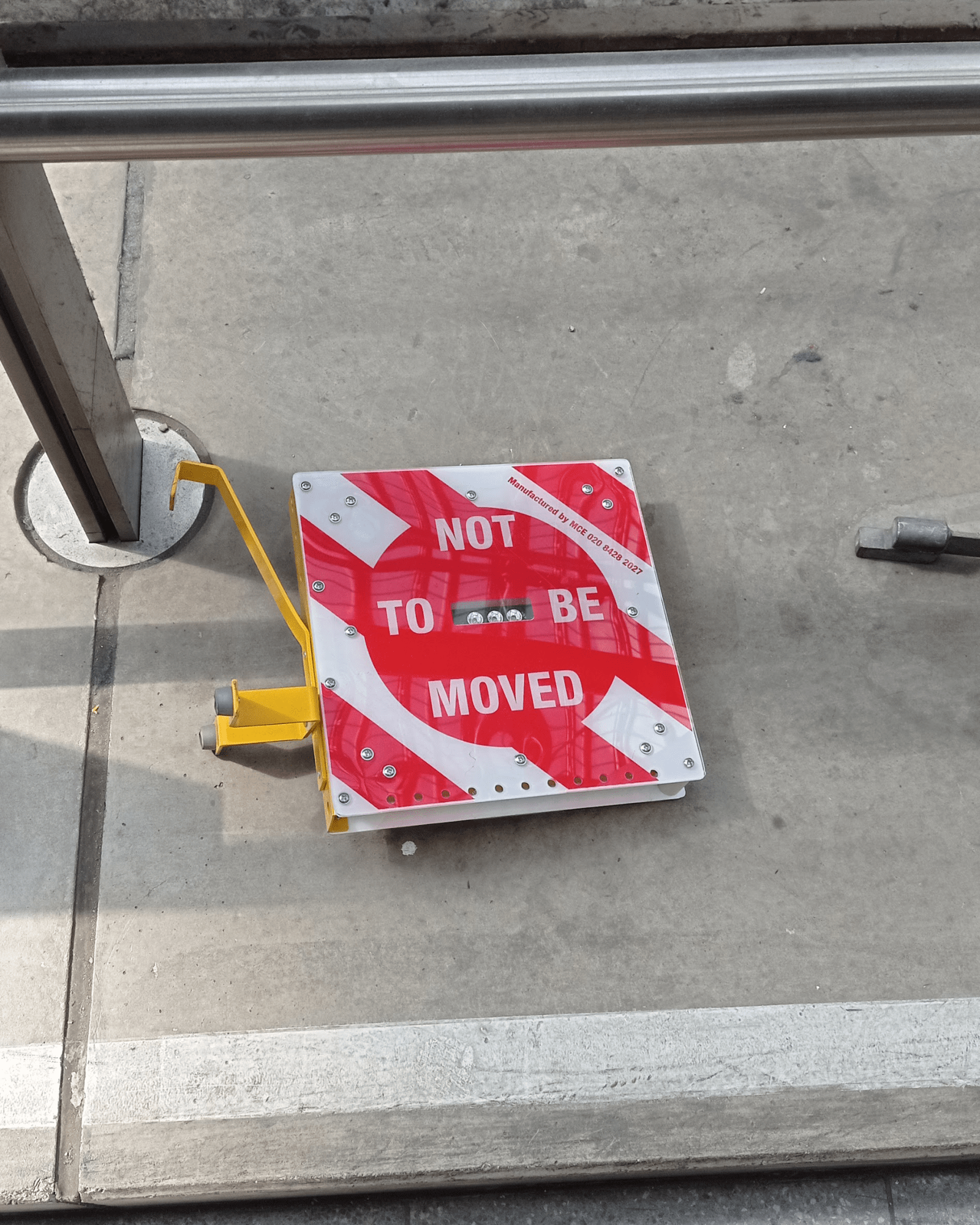 under any circumstances - an object is left on the ground in a public space. The object only bears one message : "not to be moved" - plexiglas, metal, yellow paint, strong message - paul lahana