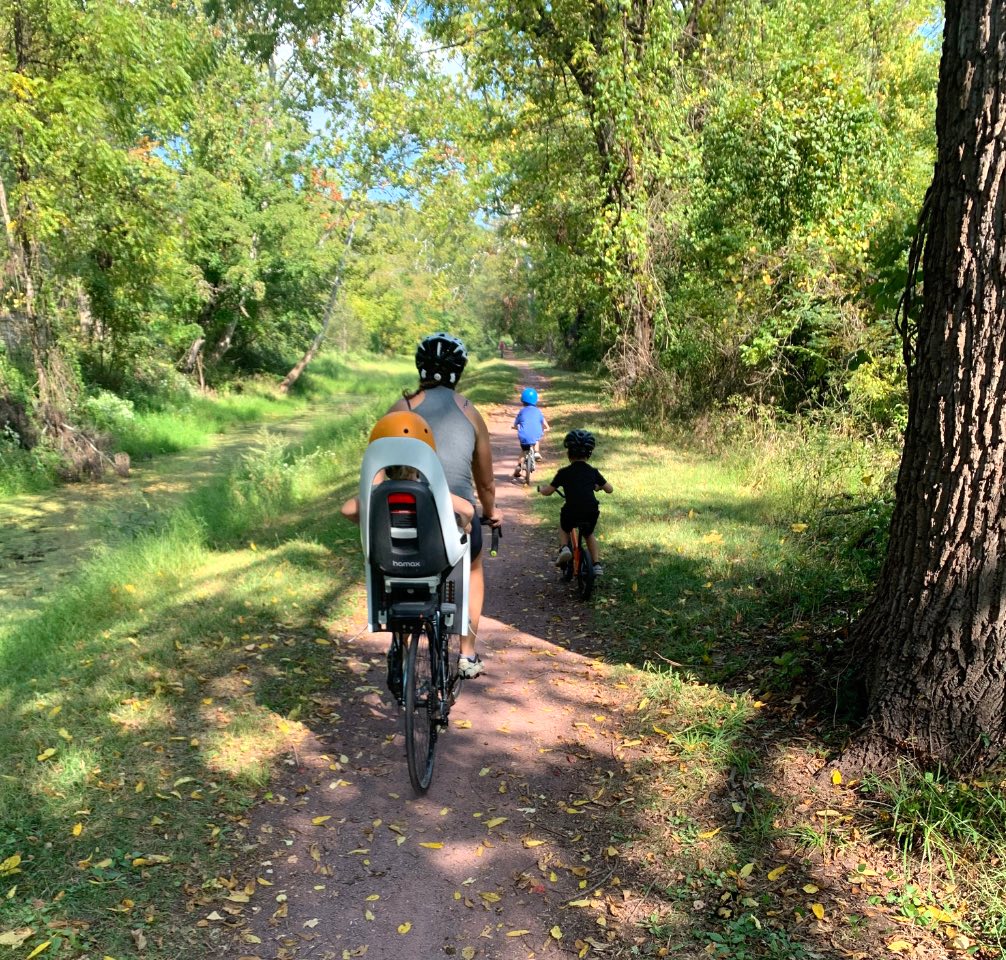 two kids riding and toddler on back bike seat on family bike ride in bucks county pa