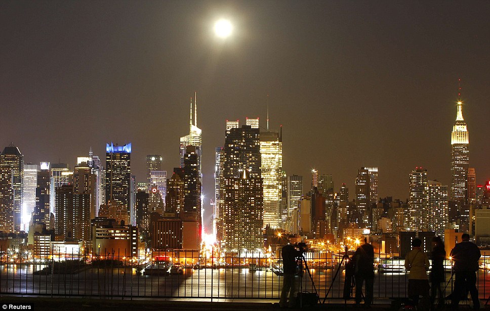 A supernatural delight: The moon appears to be as bright as some of the tallest buildings and busiest parts of New York City. The brightness of Times Square can be seen directly below the moon's rays