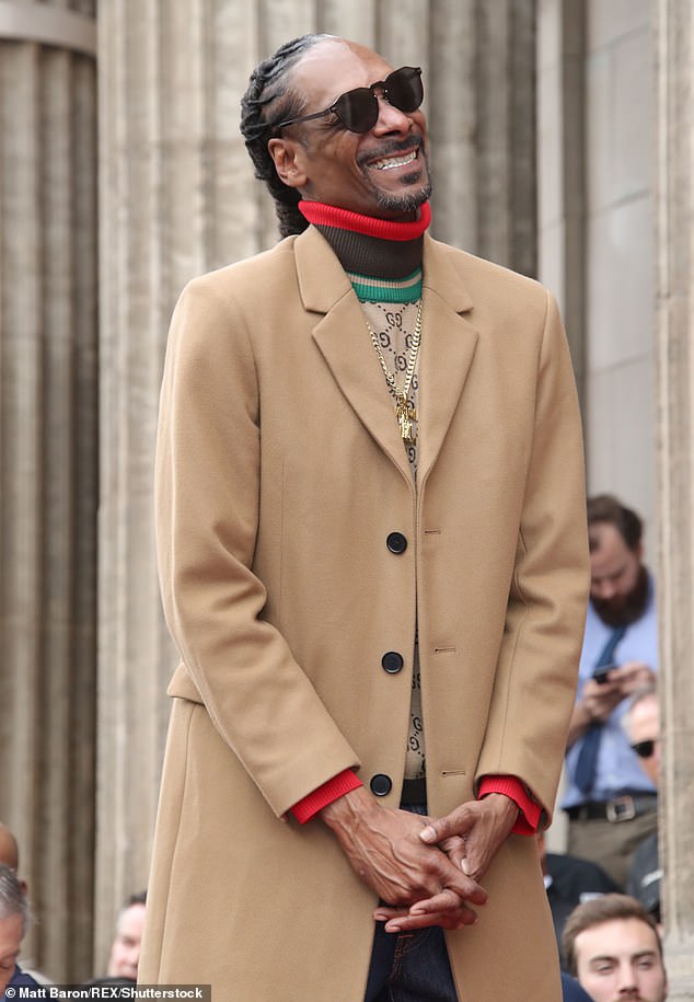 Nuthin' but a G Thang: Donning a long tan coat with a beige turtleneck underneath, the Gin and Juice rapper couldn't keep the smile from his face