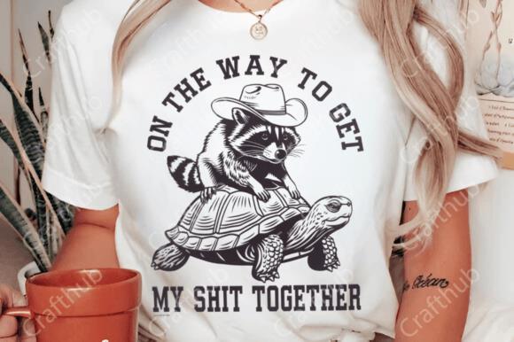 Woman wearing sarcastic raccoon graphic t-shirt with 'On the Way to Get My Shit Together' text