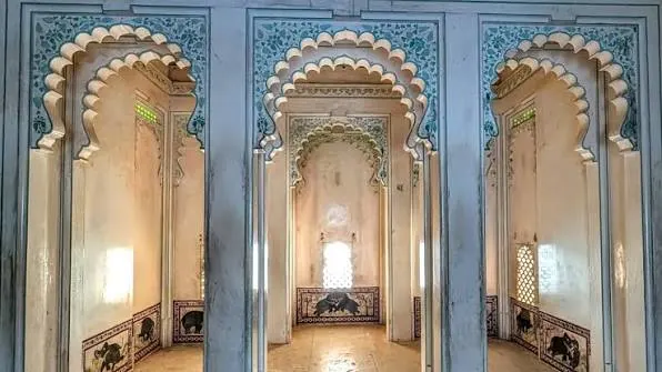 Three scalloped arches with a small window in the middle inside Badal Mahal at Kumbhalgarh Fort