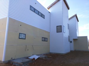 Siding on the back side. The long row of windows is the hallway.