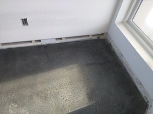 The floor in the entryway has a high density of pits from bubbles in the skim coat that was applied. Not sure what will happen to this.