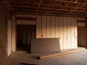 This is the wall between the house and garage. This wall is open on both sides, so they staple up some temporary fabric on one side before they spray. The rest of the garage is typical pink fiberglass.
