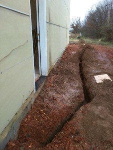 The electrical service trench from the transformer to the house was dug. The heat needs to be turned on soon so tiling can begin.