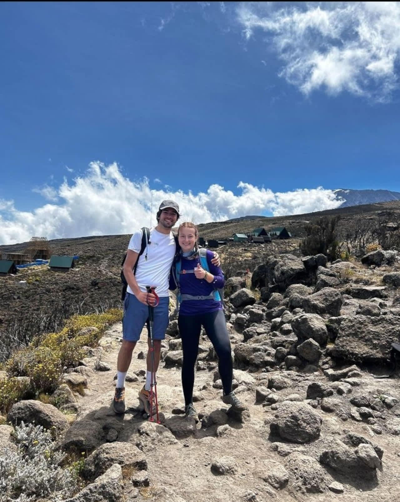 Climbers on Mount Meru summit ridge with Kilimanjaro in background