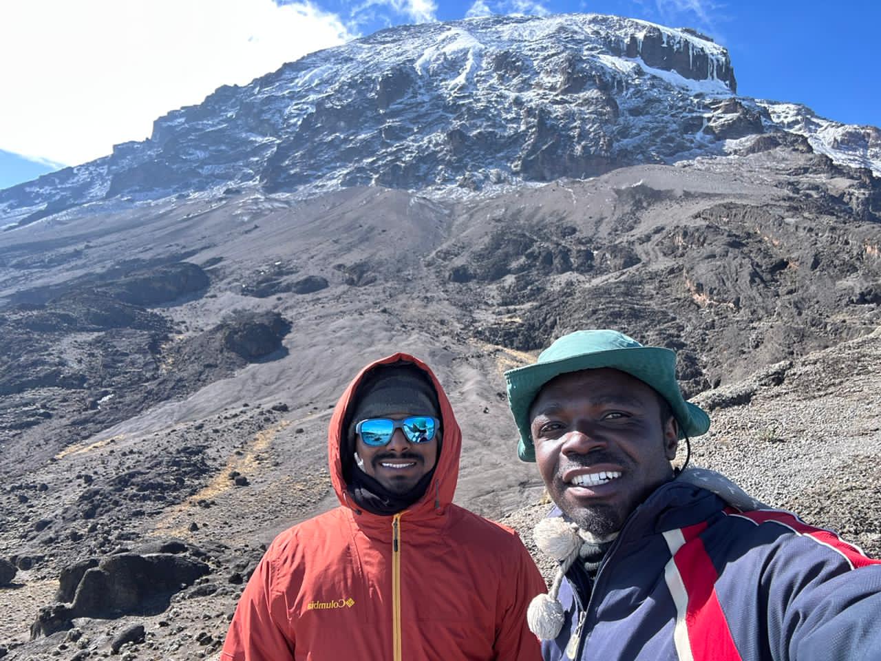 Trekkers climbing the famous Barranco Wall on Machame Route with glaciers visible above