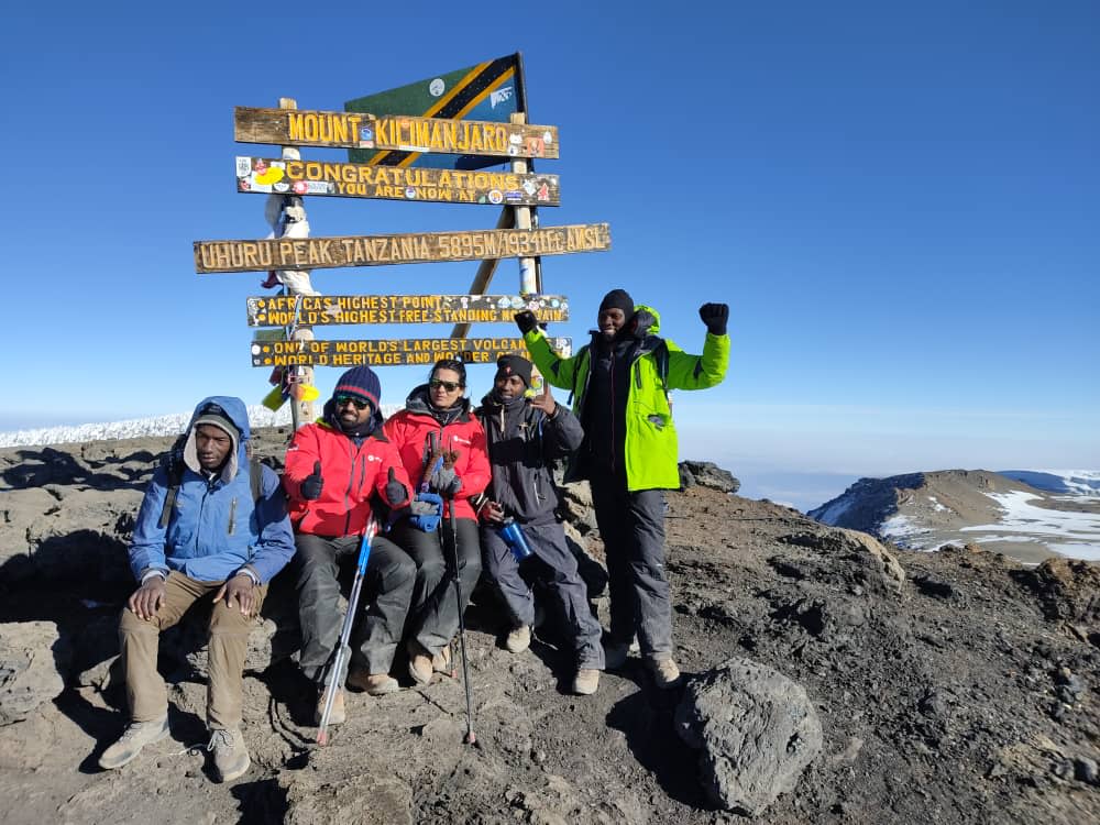 Trekkers crossing the vast Shira Plateau on Lemosho Route with Kilimanjaro summit in distance