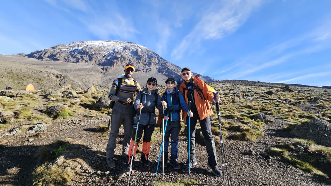 Trekkers crossing Shira Plateau on Lemosho Route with Kilimanjaro peak