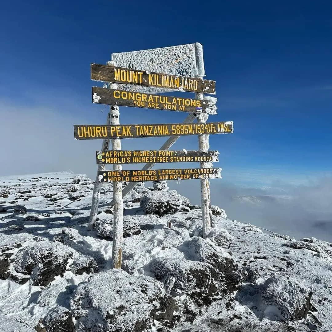 Trekkers on acclimatization hike around Mawenzi Tarn with dramatic peak backdrop on Rongai Route
