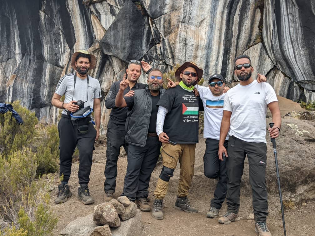 Hikers resting at Horombo Huts during 2-day Marangu Route trek with Kilimanjaro peak in background