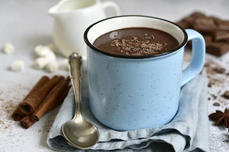 Hot chocolate - winter spicy drink in a blue cup on a light slate, stone or concrete background. Stock Photo