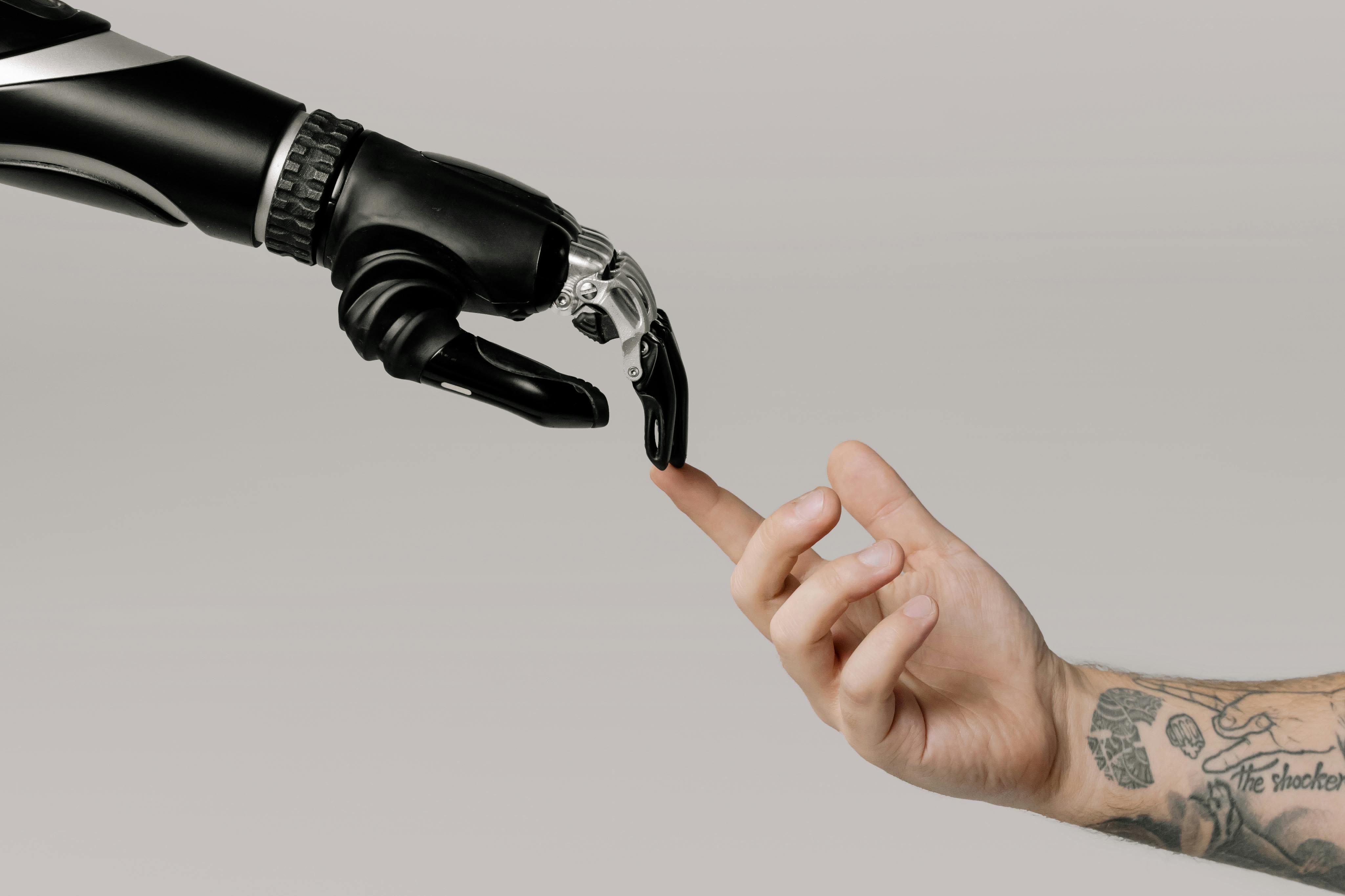 A robotic hand and a human hand with a tattoo pointing at each other expressing how Ai improves customer experiences.