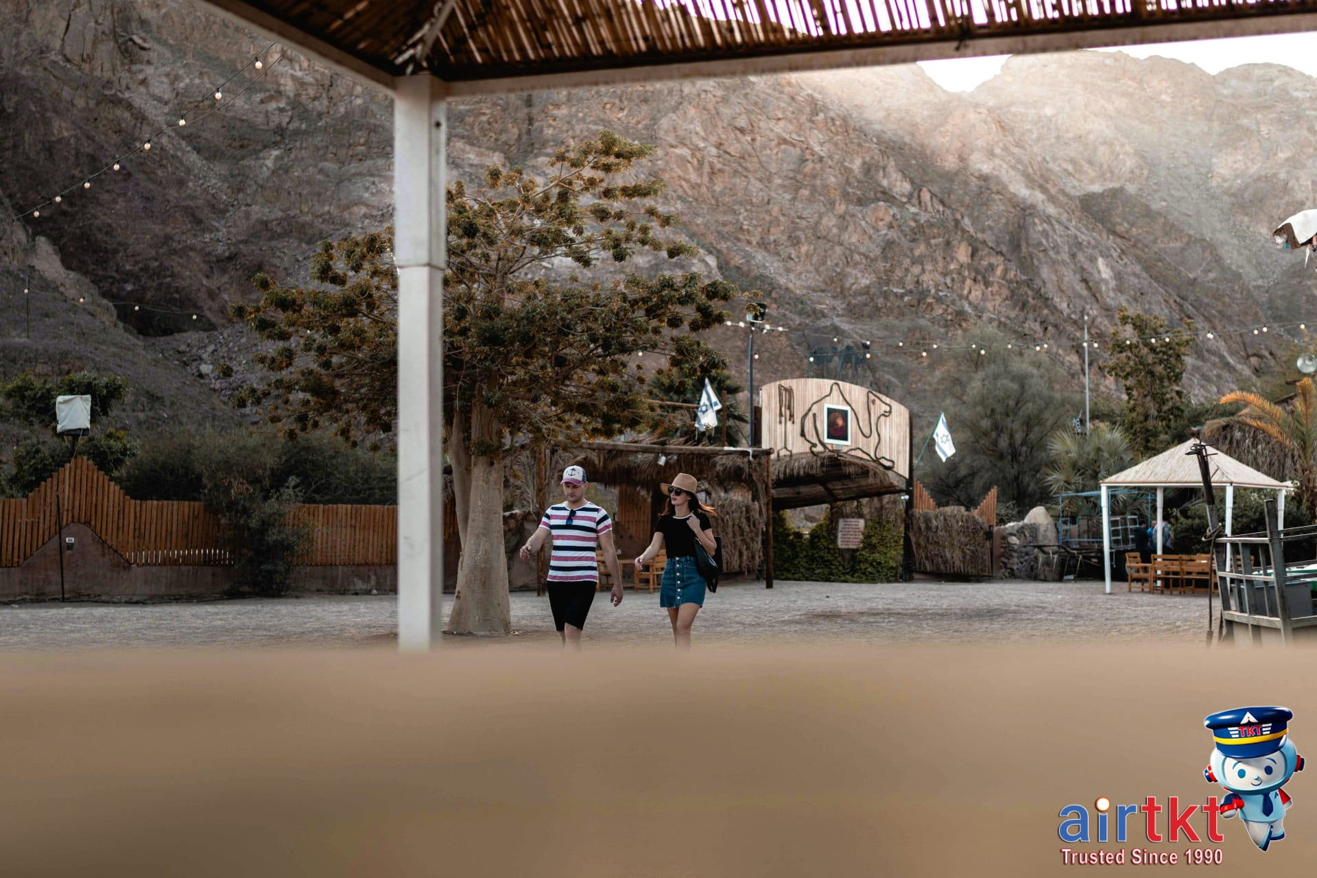 Couple enjoying a romantic beach sunset while family plays nearby