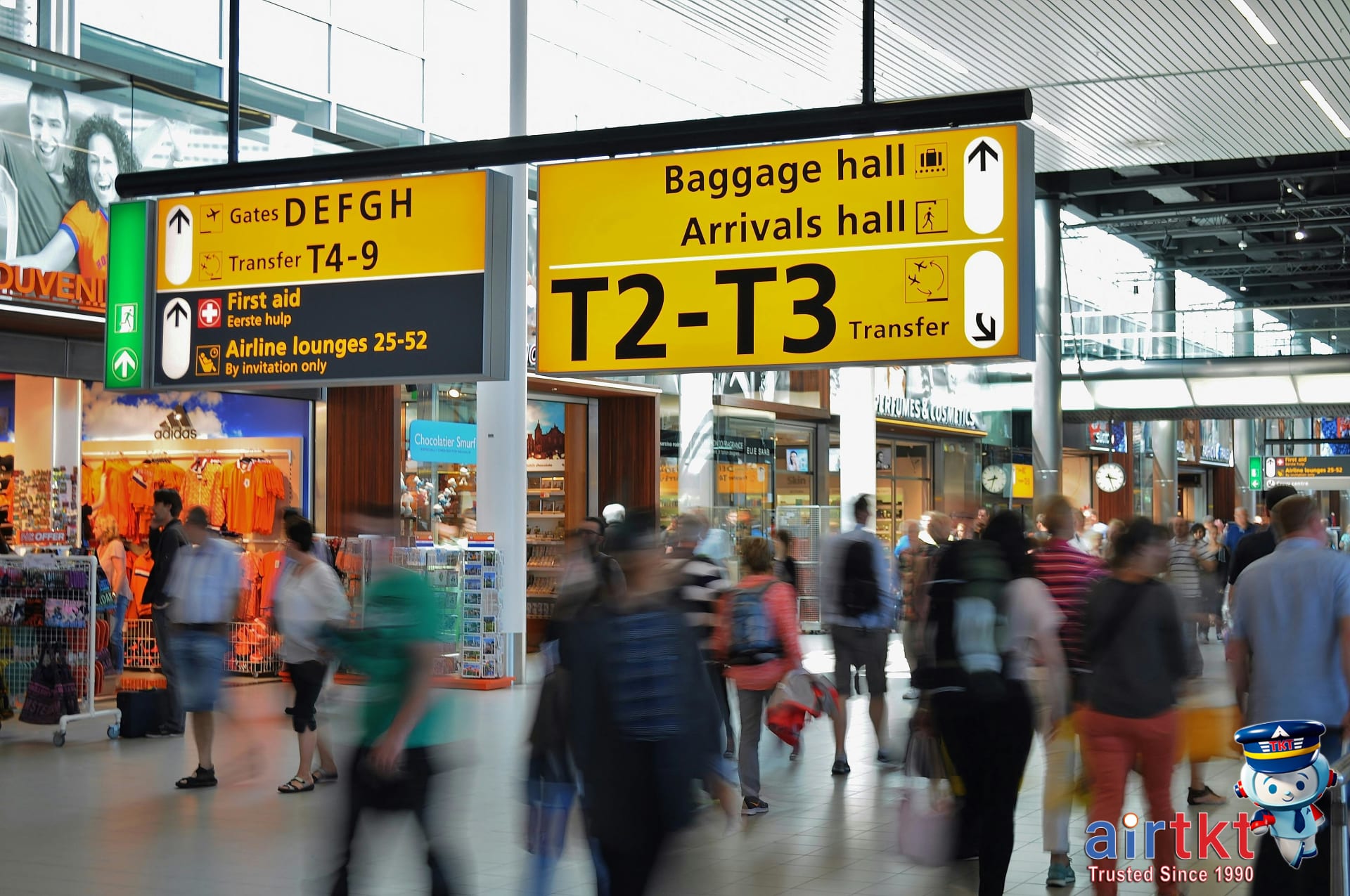 Crowded airport terminal with passengers and clear signs