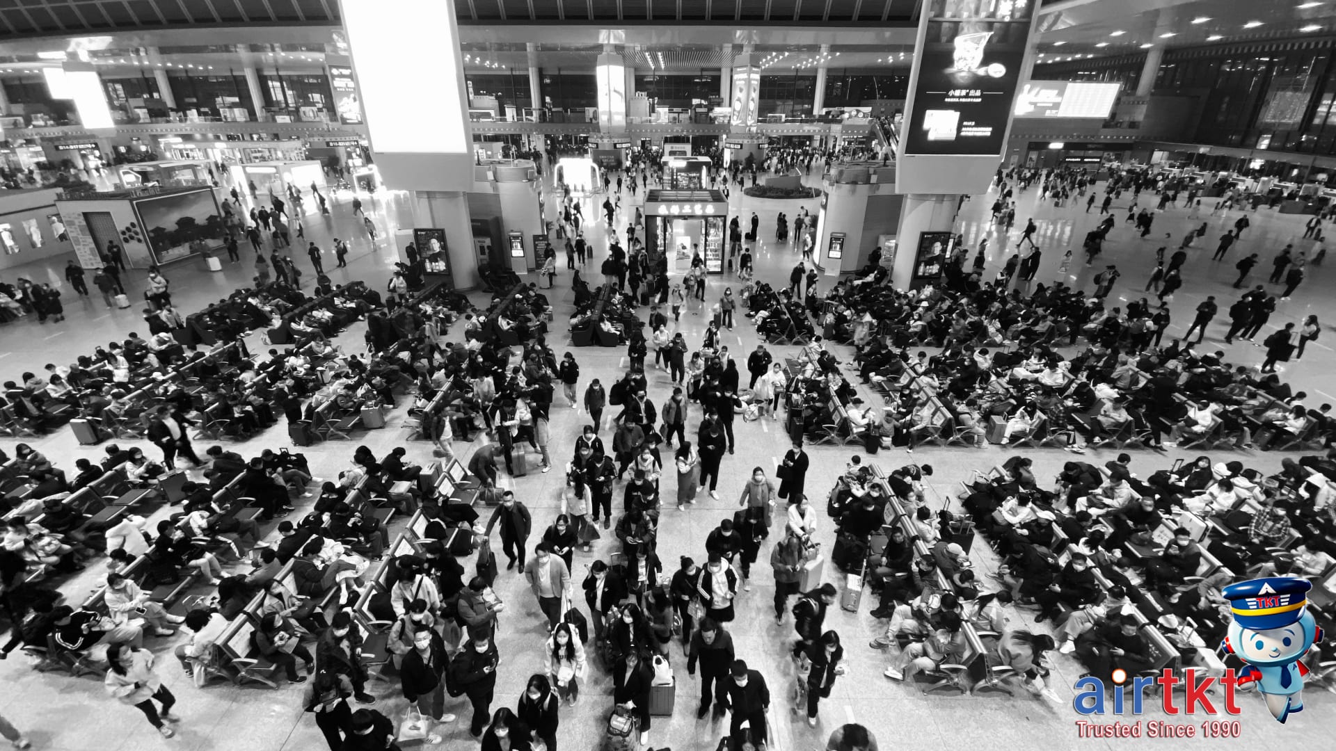 Crowd of people walking and sitting in a bustling airport terminal