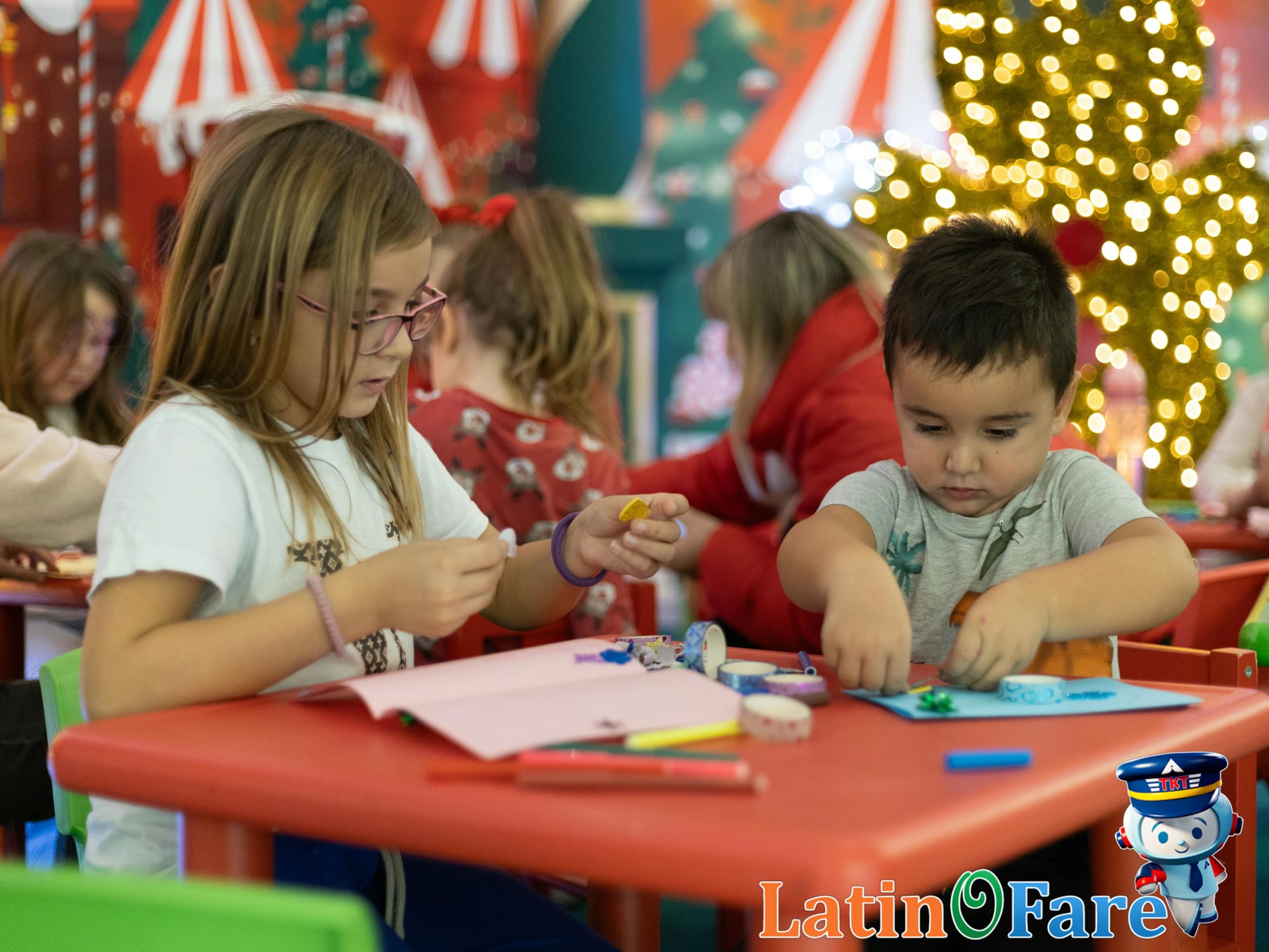 Children creating festive crafts in Christmas-themed classroom