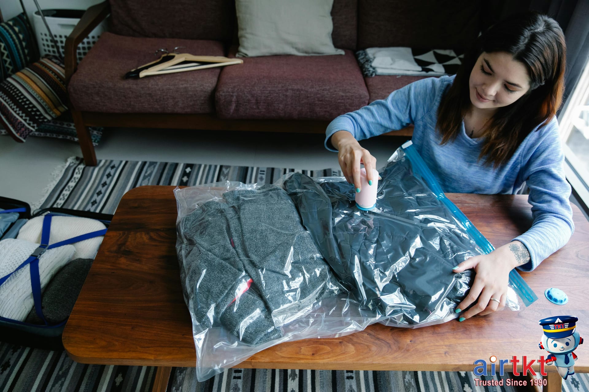 Traveler organizing minimalist packing in suitcase