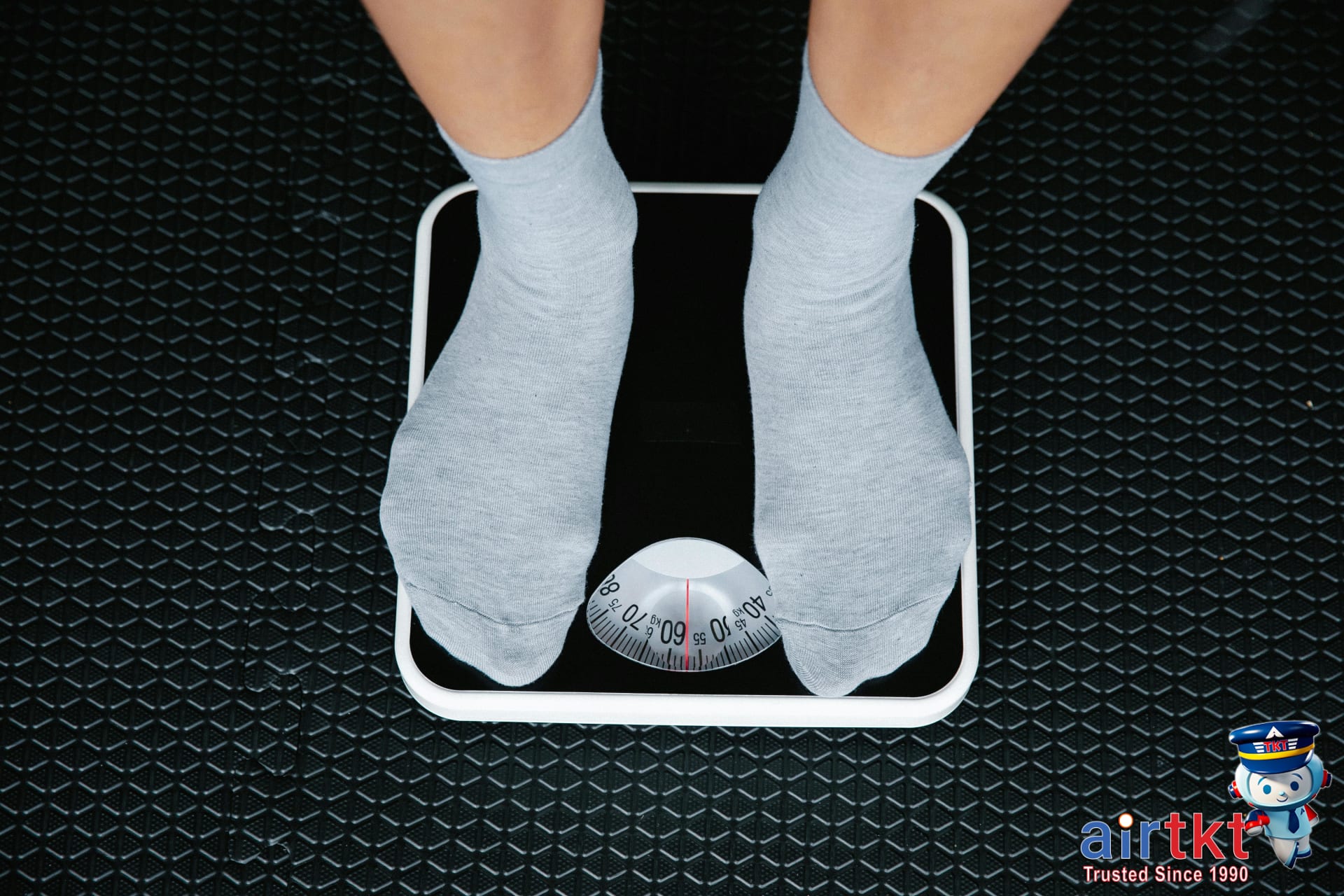 Traveler checking luggage weight on a scale